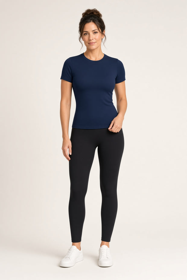 Woman wearing the Tuvi High Neck Hourglass Shirt in navy with black Golden Hour Leggings