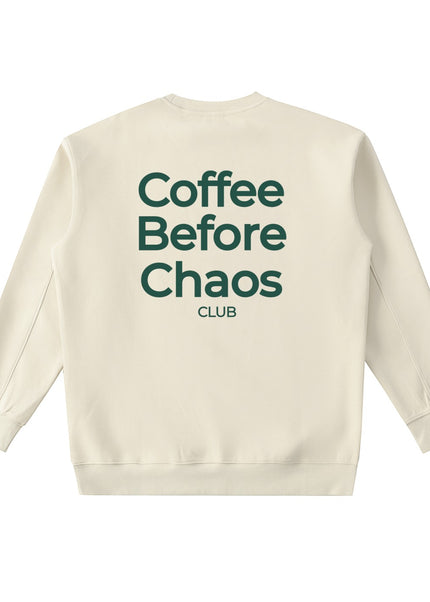 Tuvi Coffee Before Chaos Crewneck in camel, laid flat from the back, showing the large dark green Coffee Before Chaos Club print.